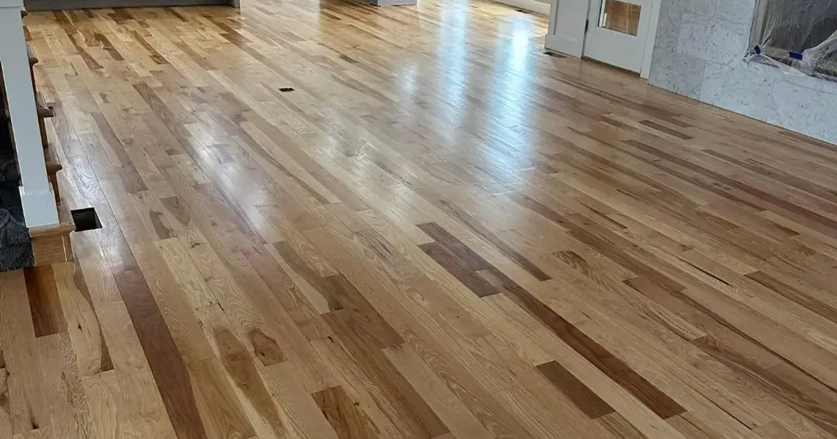 Newly installed solid oak hardwood across the main floor of a Kansas City home, the above grade, wood subfloor setting where solid hardwood outlasts engineered through repeated refinishing