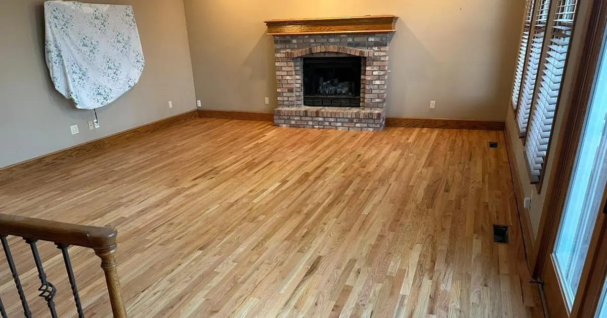 Oak hardwood floor in a Kansas City living room after JRK Flooring sanded and refinished it, the final step of a board replacement repair that blends new boards into the existing floor